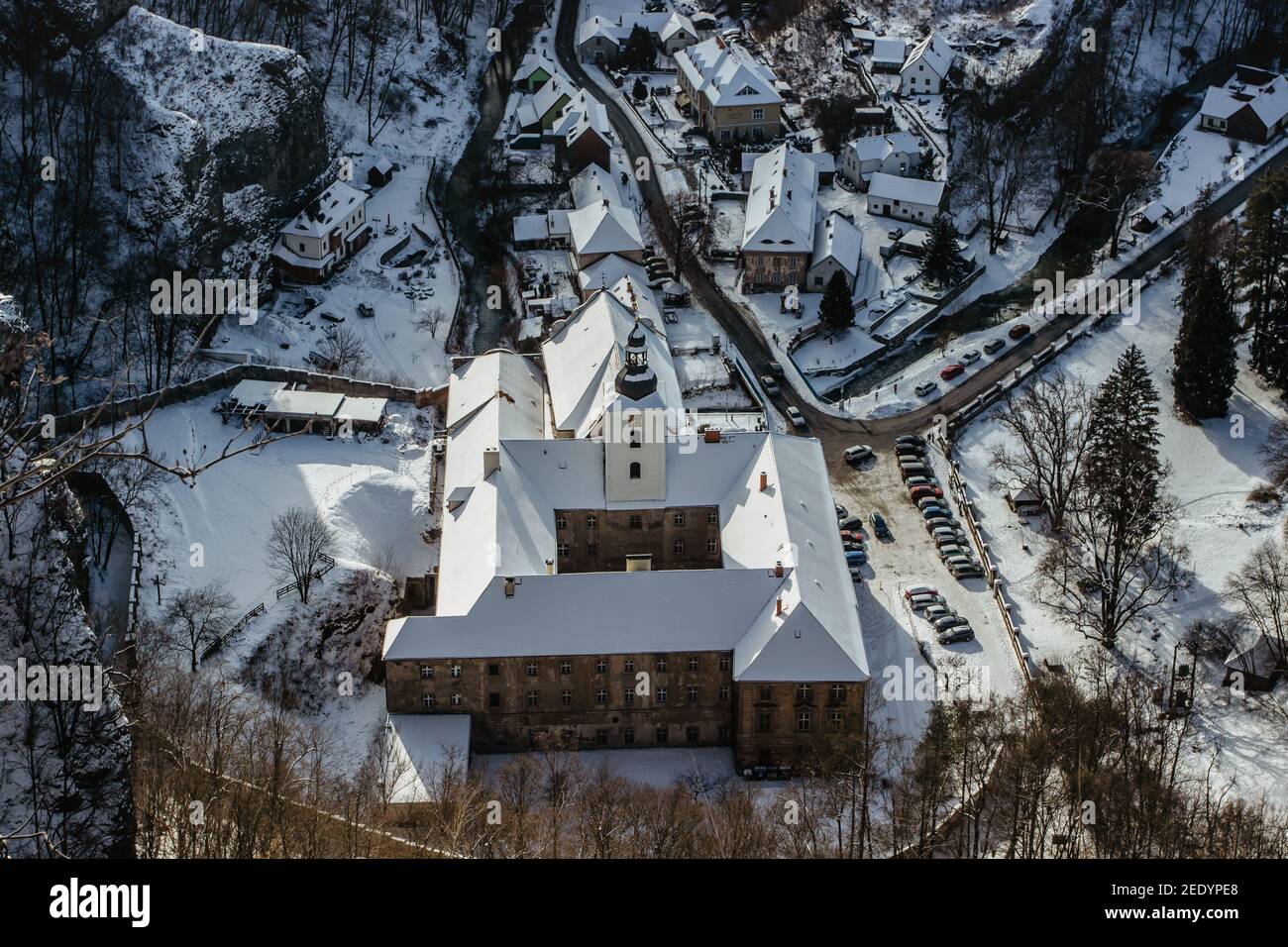 Vista aérea de invierno de Svaty Jan pod Skalou, pequeño pueblo pintoresco en Bohemia Central, República Checa. Monasterio escondido bajo acantilados y rocas Foto de stock