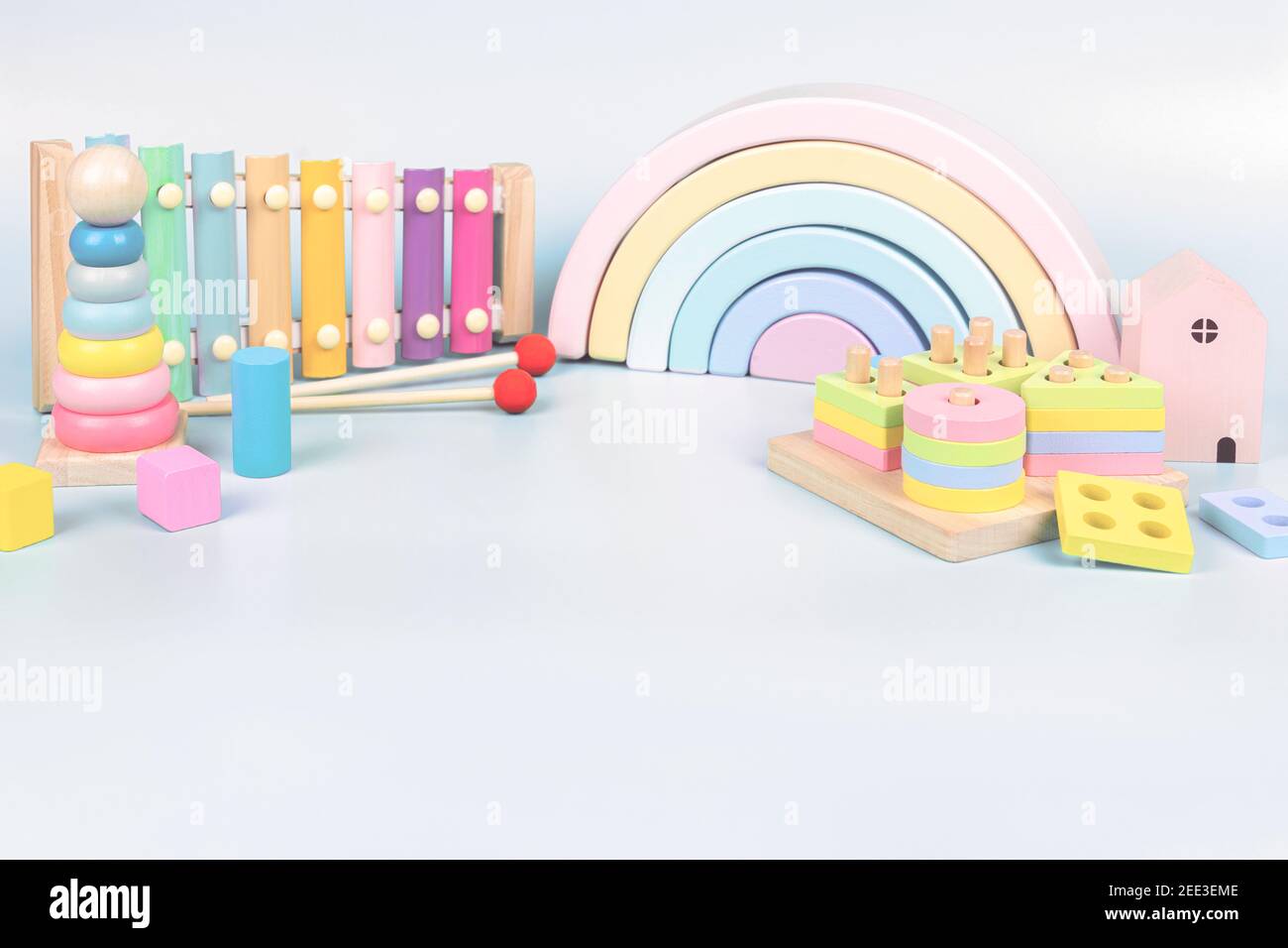 Colección de juguetes para niños. Arco iris de madera, educación y música  juguetes de bebé sobre fondo azul claro Fotografía de stock - Alamy