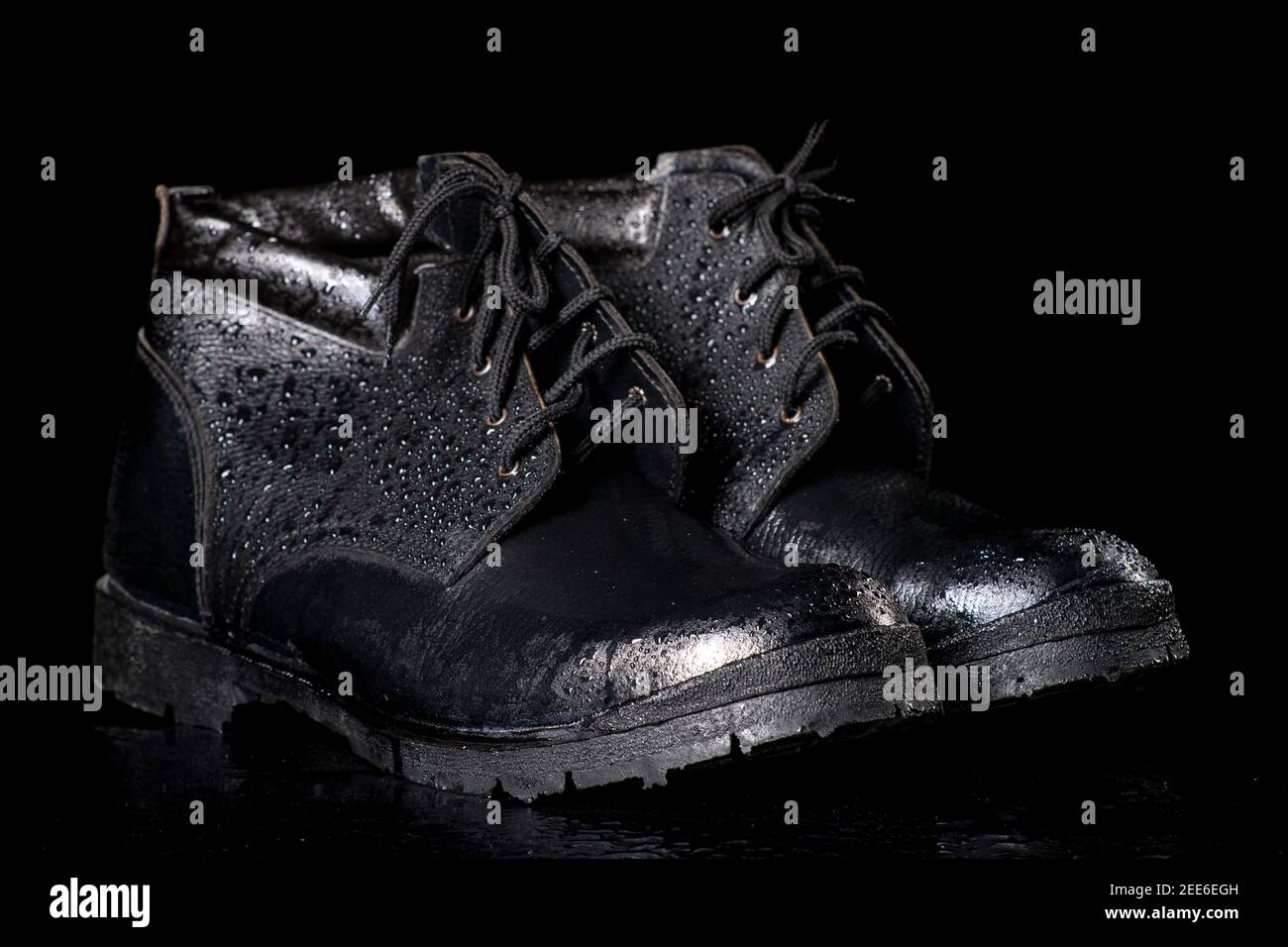 Botas negras de trabajo mojado en una mesa oscura. Accesorios de protección  para trabajadores de la construcción. Fondo oscuro Fotografía de stock -  Alamy