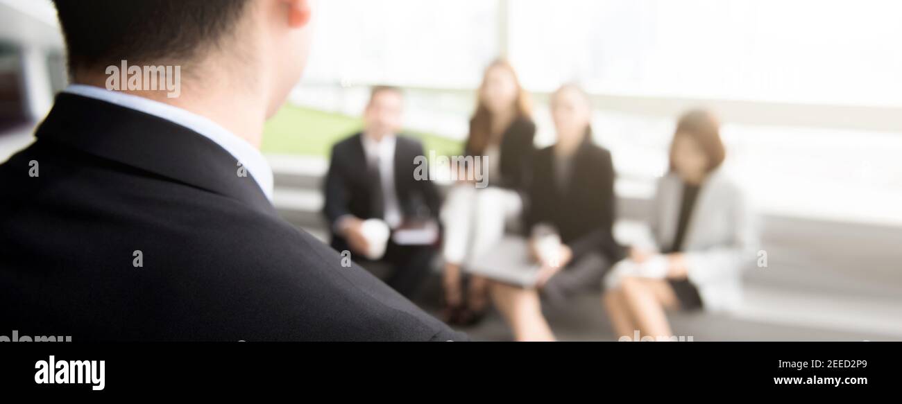 Vista posterior de un líder de un hombre de negocios hablando con un equipo profesional audiencia en una reunión o seminario - banner panorámico Foto de stock