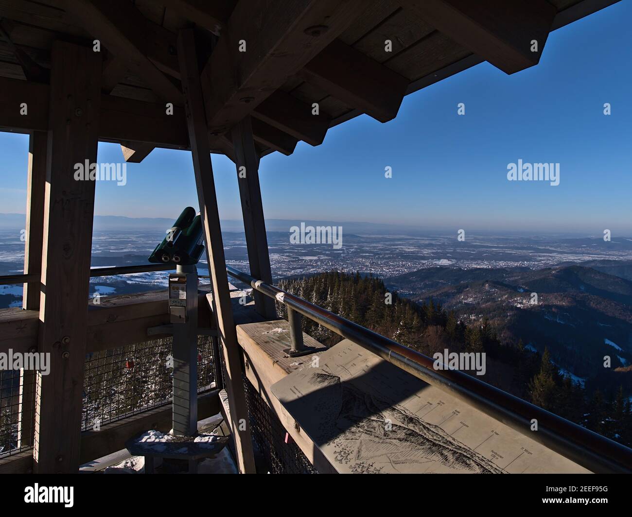 Impresionantes vistas panorámicas sobre el valle del Rin y la cordillera de los Vosgos desde la cima de la torre de observación Eugen-Keidel-Turm con prismáticos en invierno. Foto de stock