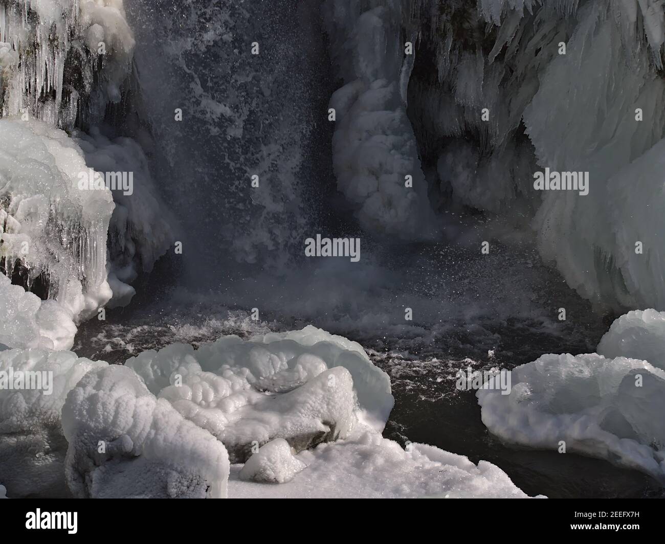 Bizarre mirando cascadas Todtnauer Wasserfälle en la temporada de invierno con rociado de agua, rocas congeladas y hielo en el soleado día de invierno en la Selva Negra. Foto de stock