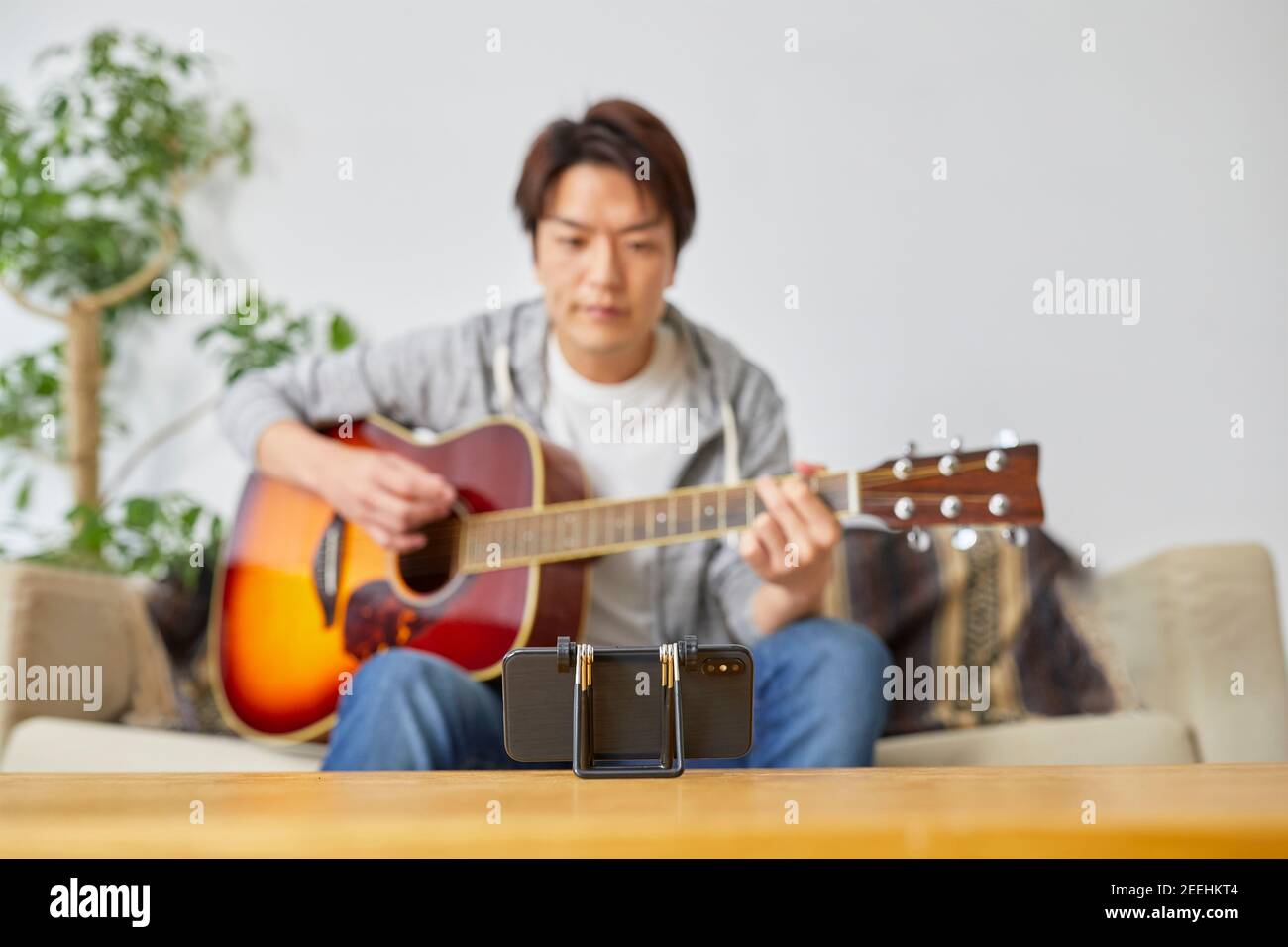 Hombre japonés tocando la guitarra en casa Fotografía de stock - Alamy
