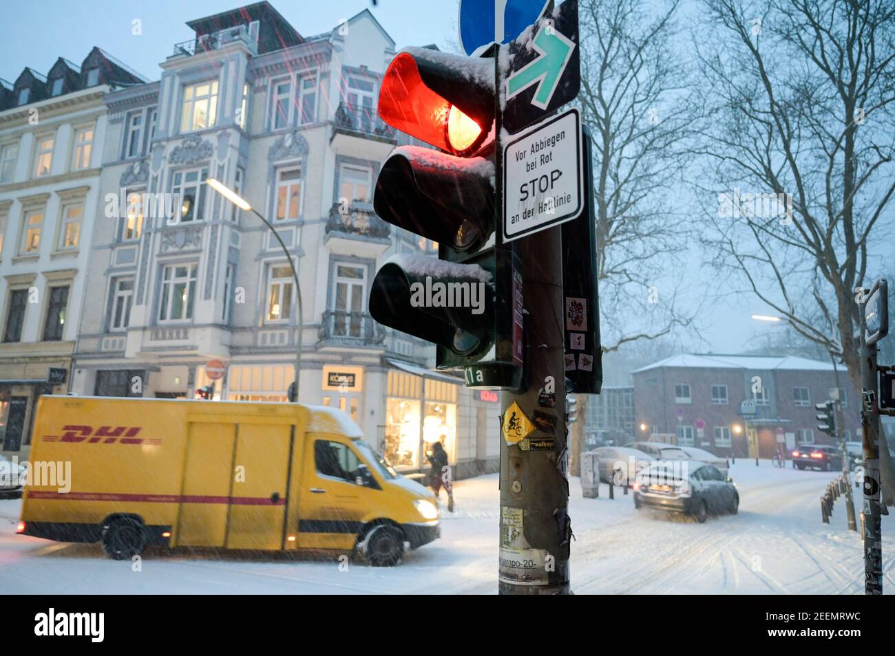 ALEMANIA, Hamburgo, invierno, nieve, semáforo rojo, vehículo amarillo DHL, servicio de entrega de paquetes Foto de stock