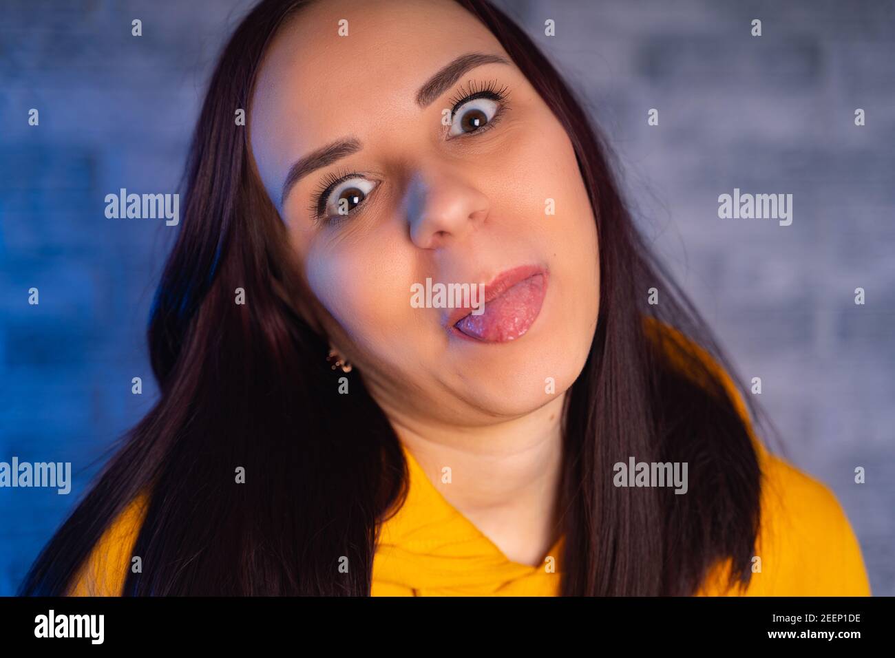 Una mujer joven en un hoodie amarillo de moda muestra el idioma