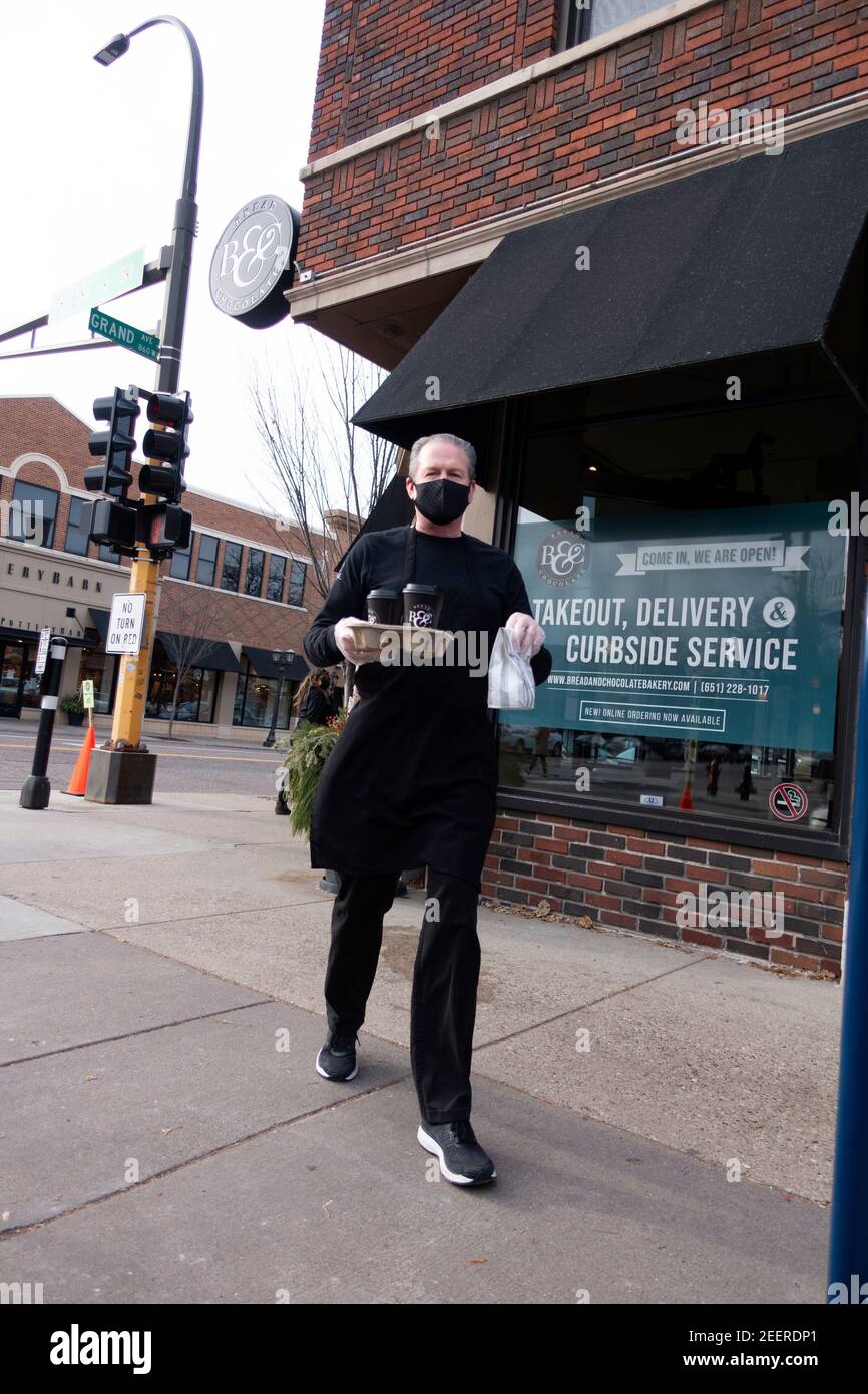Servicio al lado de la acera por camareros enmascarados y enambrados trayendo cafés y pasteles al coche desde el café de Pan y Chocolate. St Paul Minnesota MN EE.UU Foto de stock