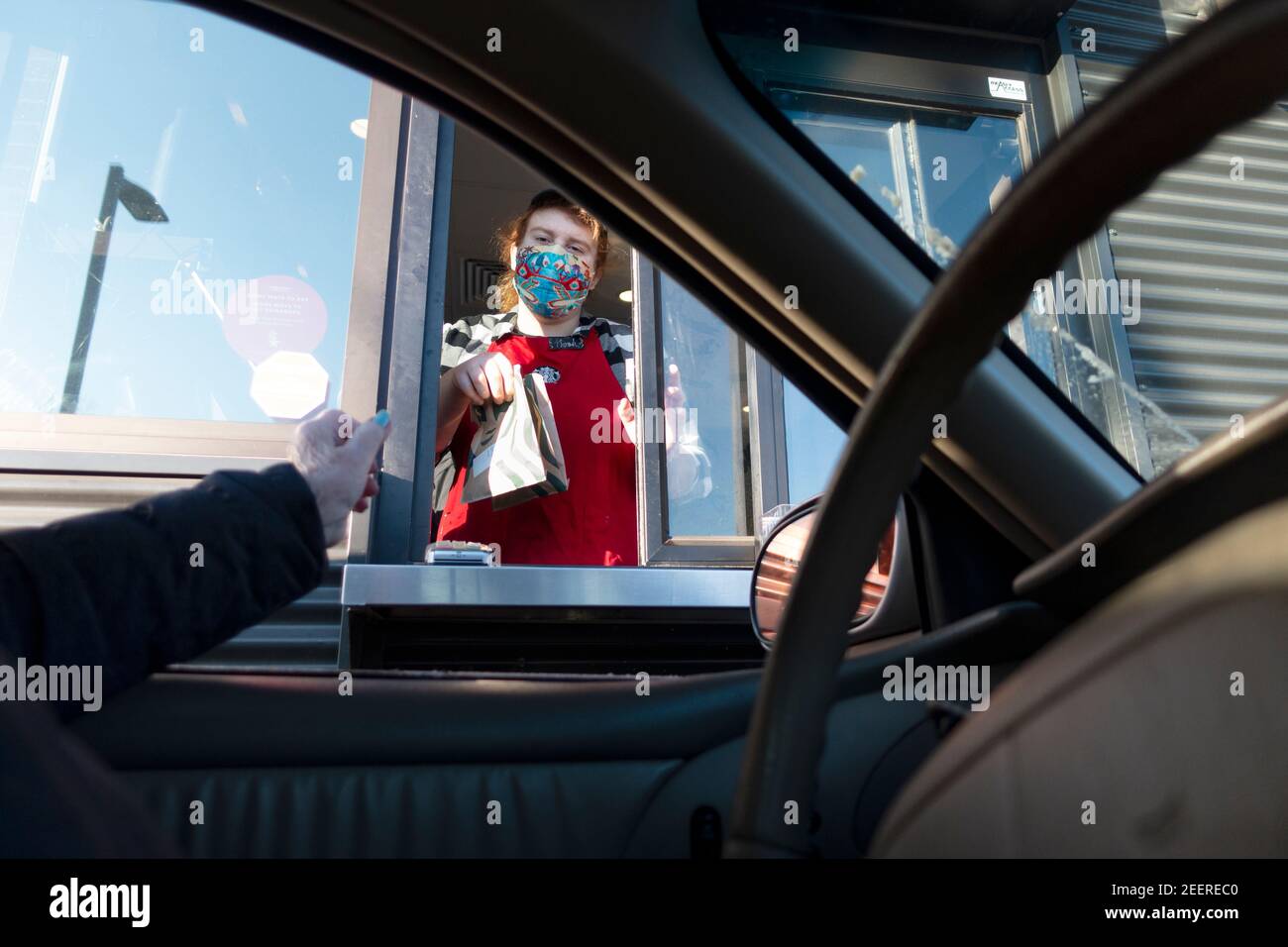 Cajero de Starbucks enmascarado entregando la bolsa de la patrona de los pasteles mientras que el café se está preparando durante la Pandemic de Covid. St Paul Minnesota MN EE.UU Foto de stock