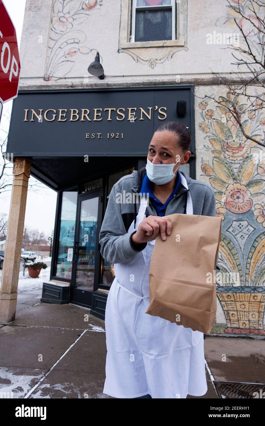 Carnicero de la tienda sueca de Ingebretsen que trae orden de lutefisk al lado del curbside. Minneapolis Minnesota MN EE.UU Foto de stock