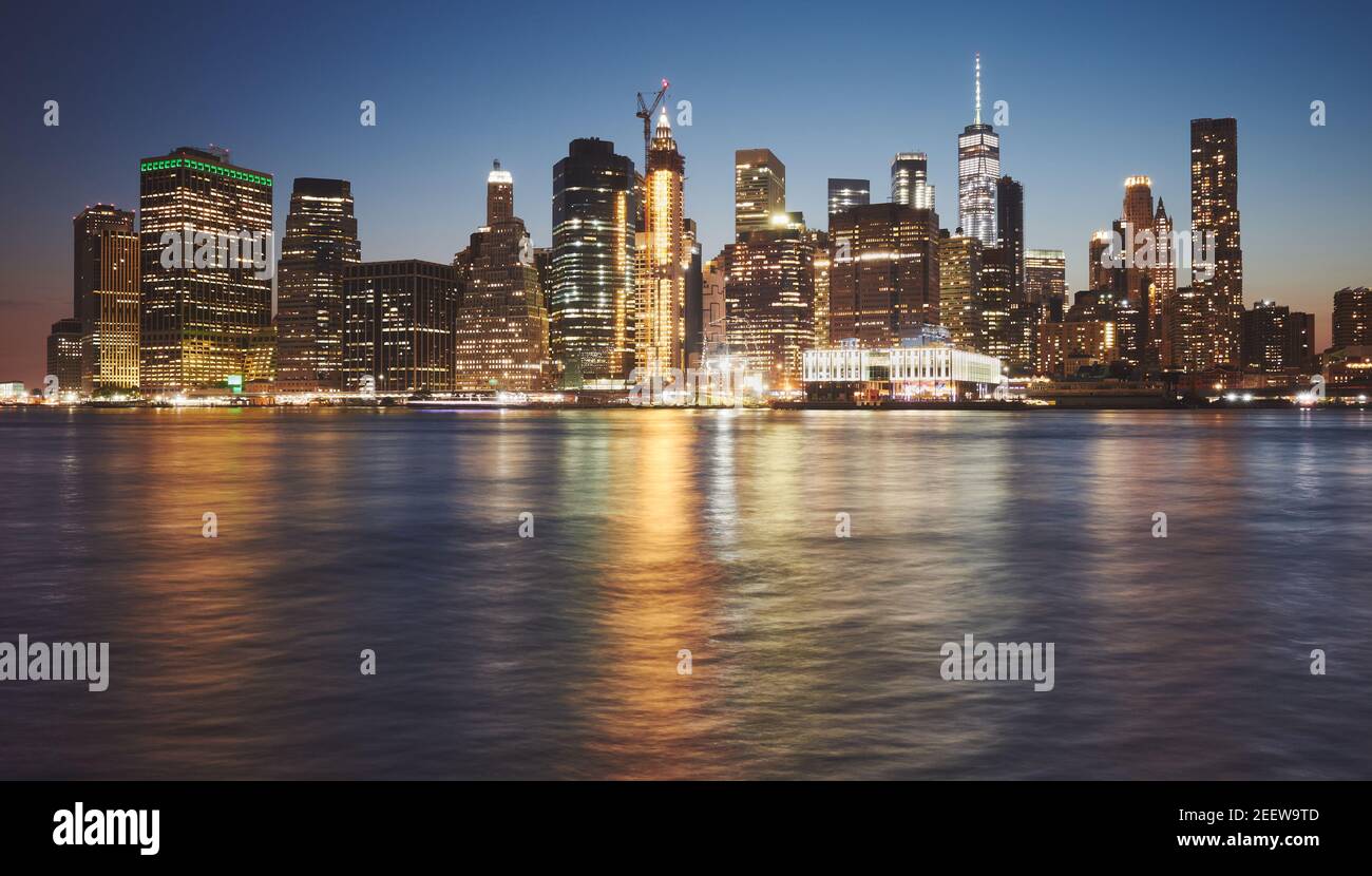 El horizonte de Manhattan se refleja en el agua al atardecer, en la ciudad de Nueva York, EE.UU. Foto de stock