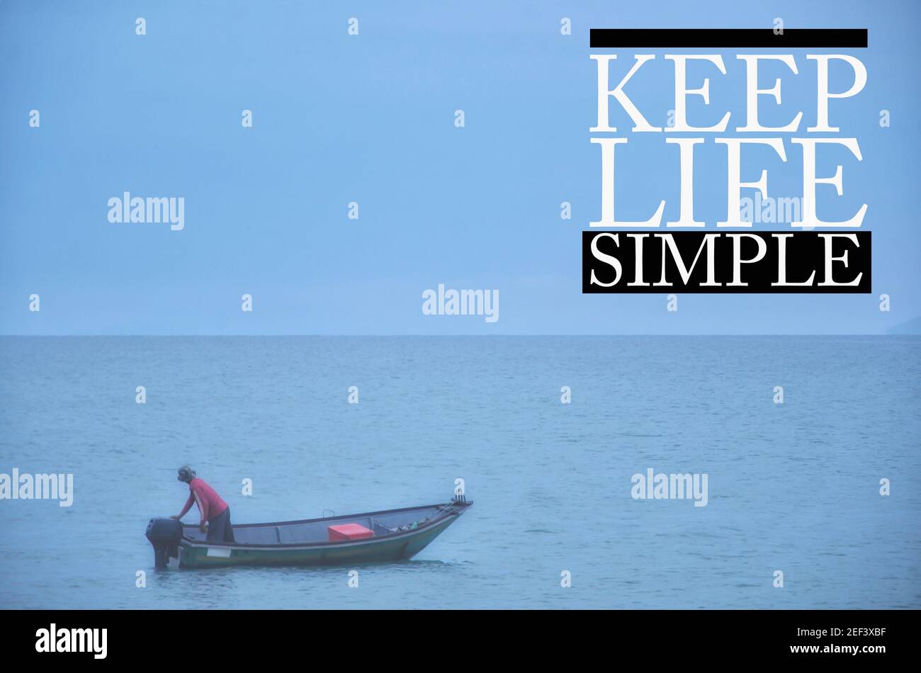 Motivación inspiradora vida Cotizaciones con el fondo de un hombre en un barco en un océano. Mantenga la vida simple Foto de stock