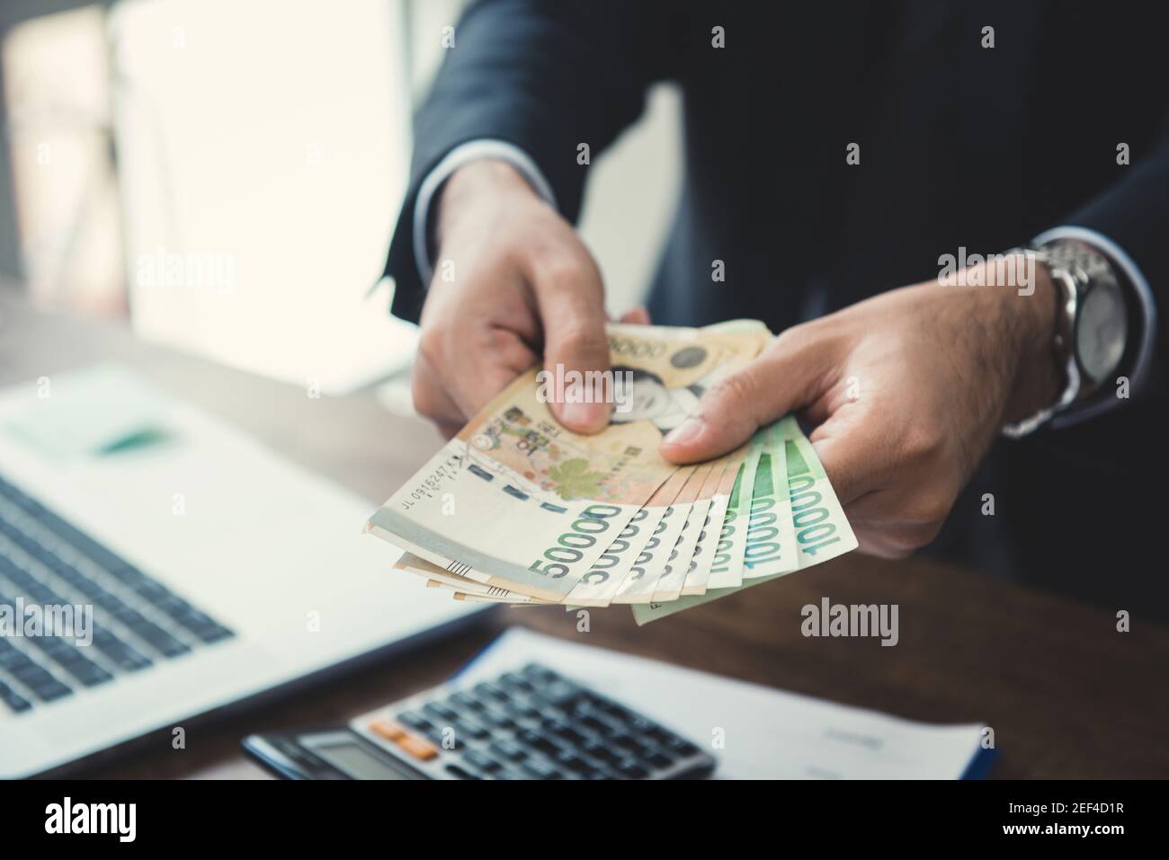 Hombre de negocios dando dinero, Corea del Sur ganó billetes Foto de stock