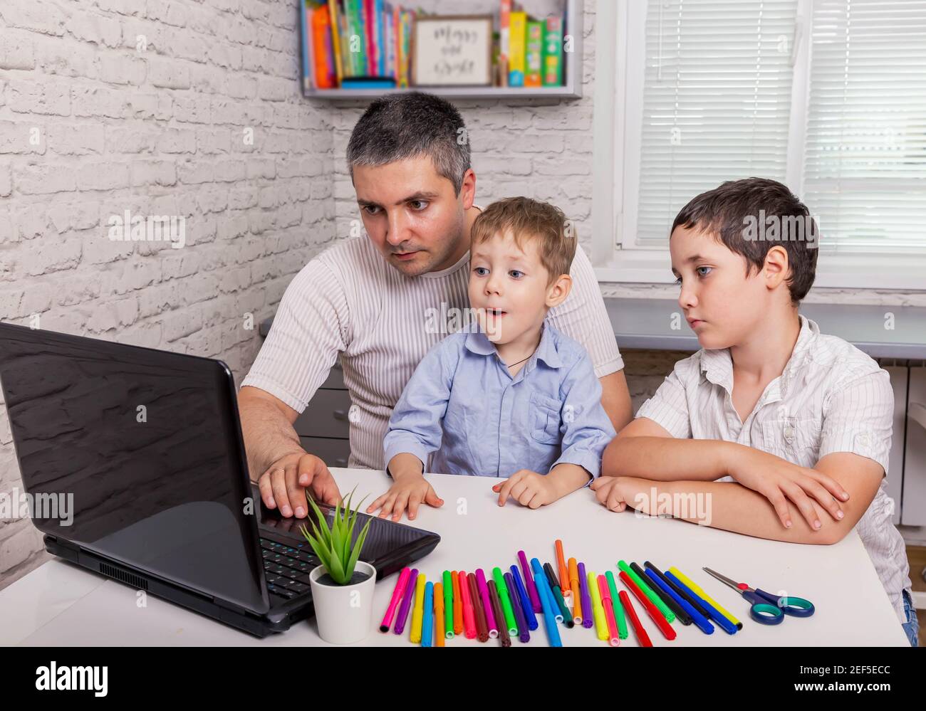 Hombre y niños haciendo video chat en la tableta en casa. Homeschooling Foto de stock