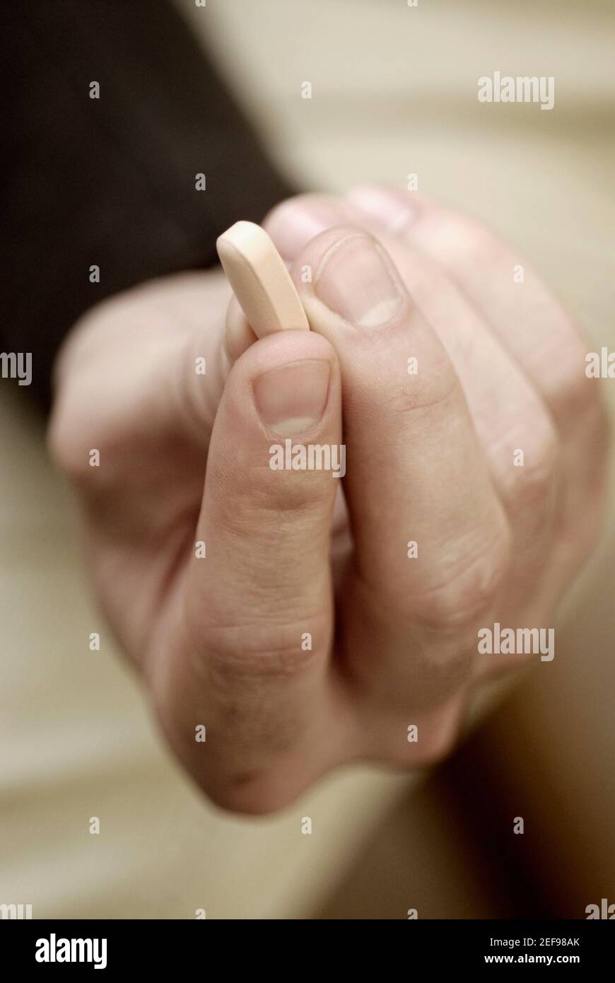 Primer plano de una mano personÅ½s sosteniendo una píldora Foto de stock