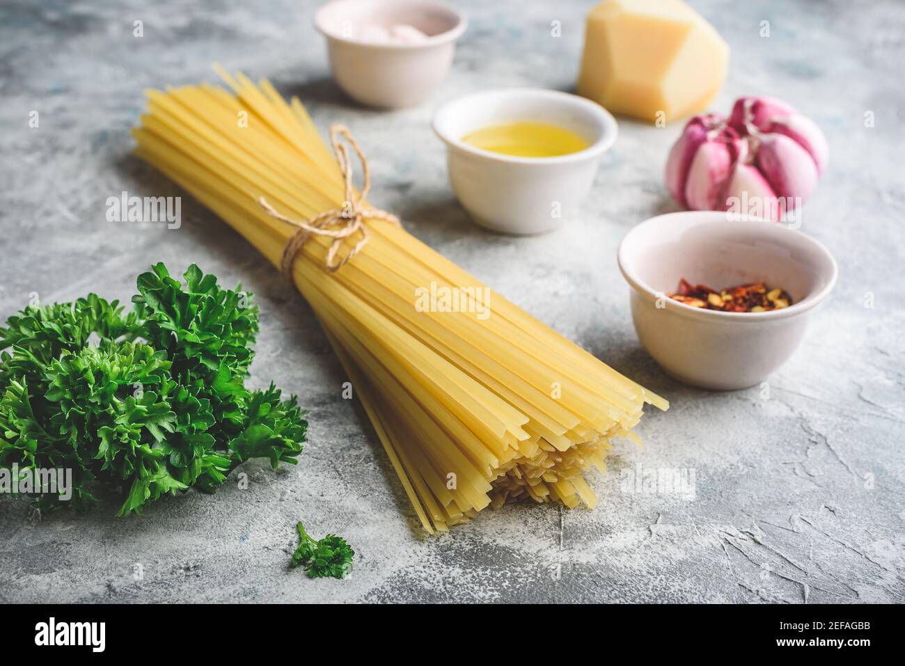 Ingredientes crudos para cocinar linguina con aceite de oliva, ajo y perejil  Fotografía de stock - Alamy