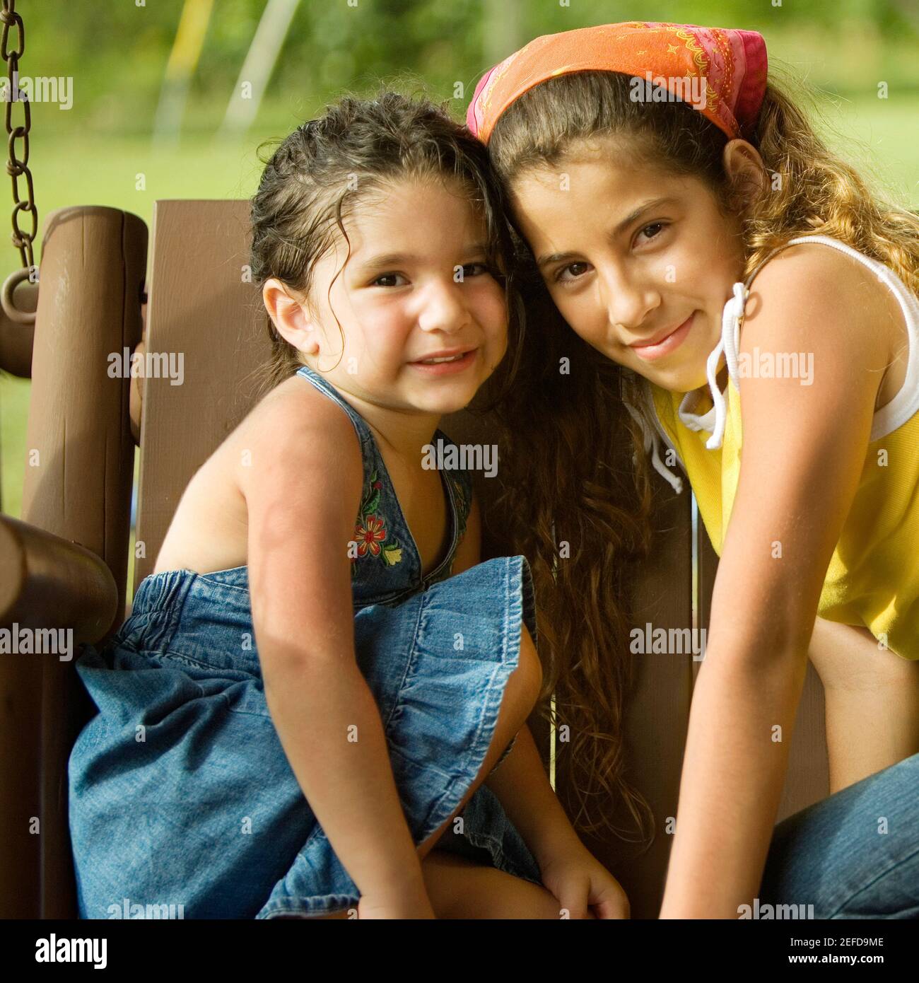 Retrato de dos hermanas sentadas en un columpio Foto de stock