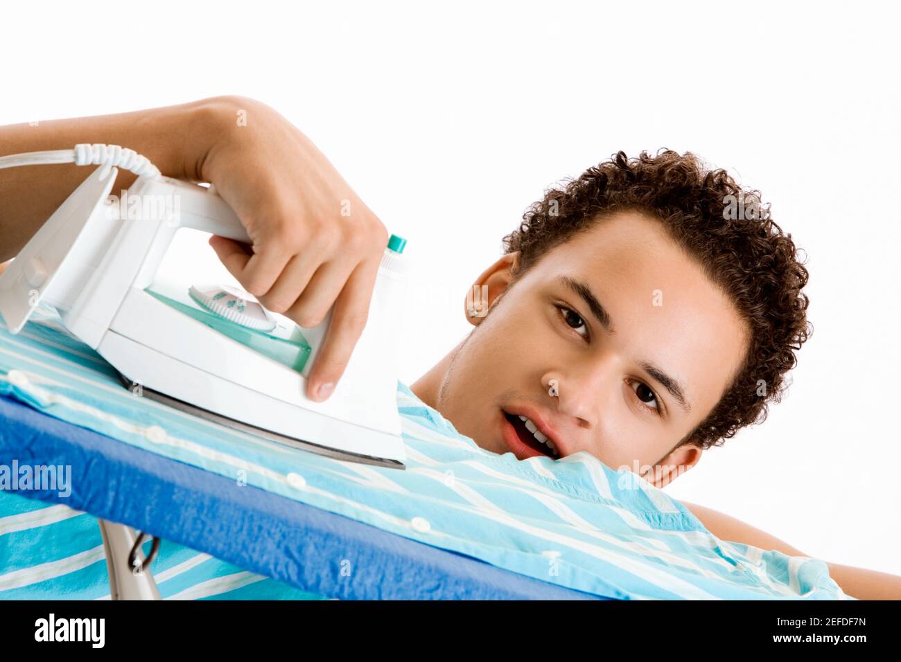 Retrato de un joven planchando su camisa Foto de stock