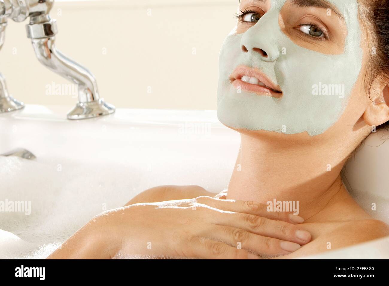 Primer plano de una mujer joven que lleva una máscara facial una bañera Foto de stock