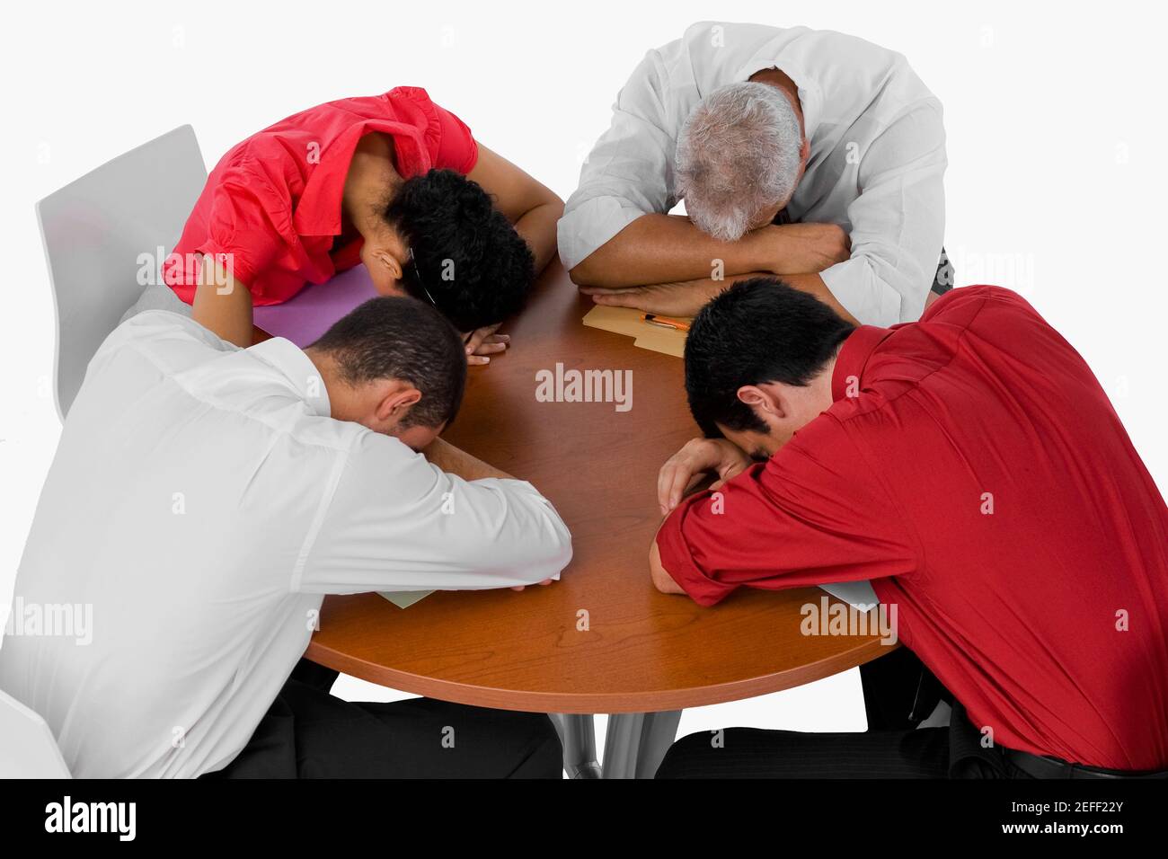 Vista angular de tres hombres de negocios y una mujer de negocios descansando sus cabezas en una mesa Foto de stock