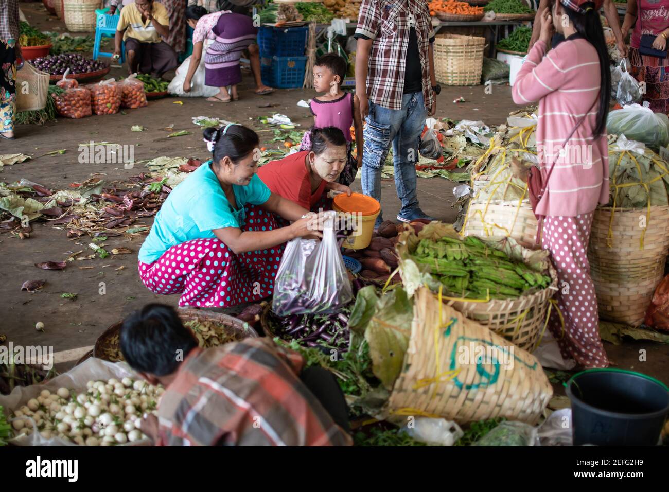 YANGON, MYANMAR - DECEMEBER 31 2019: Muchos birmanos visitan un mercado callejero local para comprar y vender frutas, verduras y comestibles en la vida cotidiana Foto de stock
