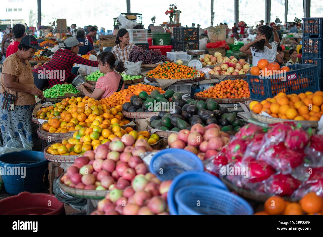 YANGON, MYANMAR - DECEMEBER 31 2019: Muchos birmanos visitan un mercado callejero local para comprar y vender frutas, verduras y comestibles en la vida cotidiana Foto de stock