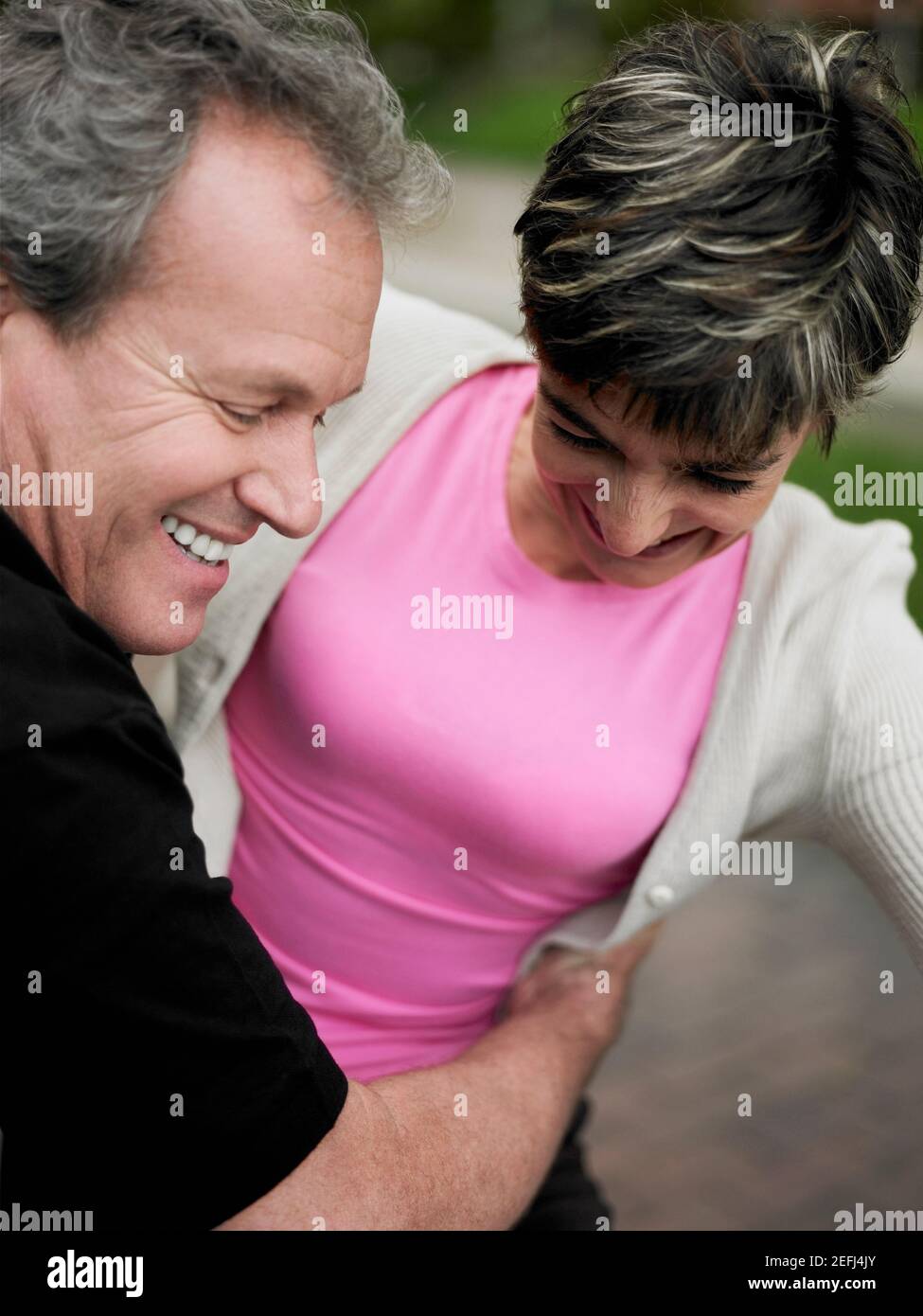 Close-up de un hombre maduro, abrazando a una mujer madura y sonriente Foto de stock