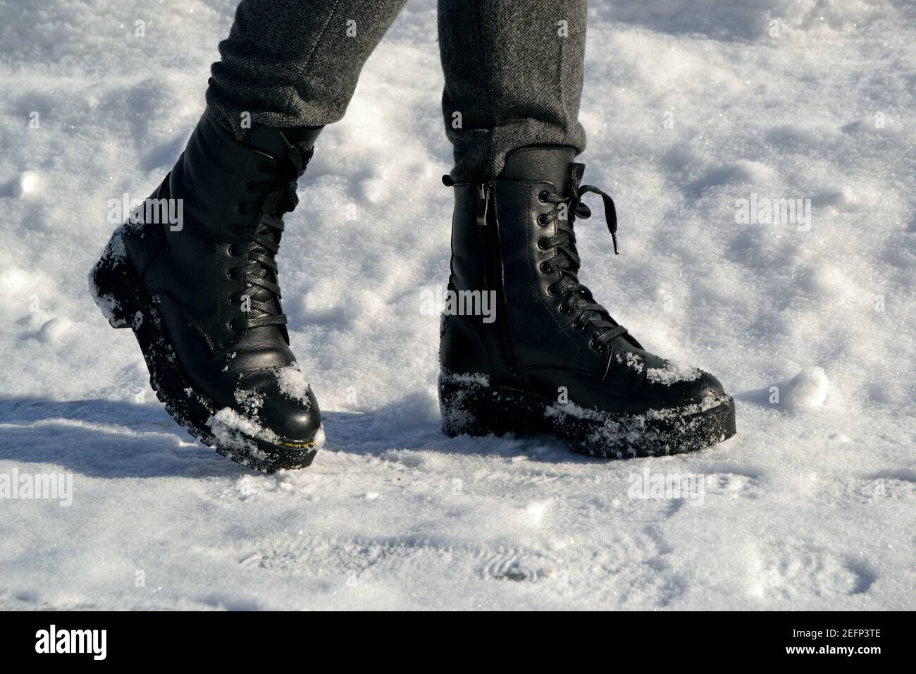 Las piernas de la mujer en botas altas negras caminando por la calle en la  nieve Fotografía de stock - Alamy