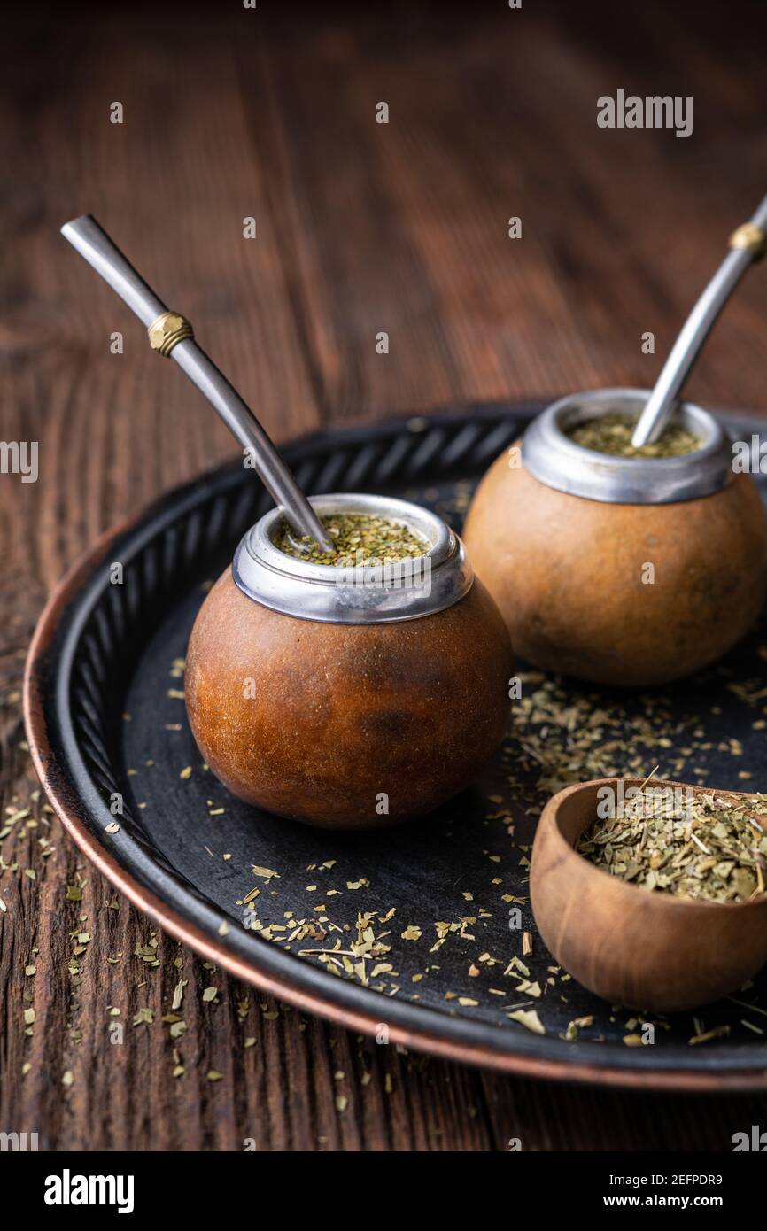 Bebida infundida saludable, té Yerba Mate clásico en una calabaza con mobilla sobre fondo de madera Foto de stock