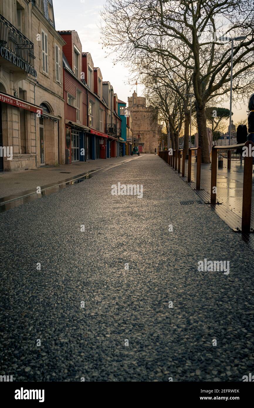 Calle vacía por la noche en la rochelle, Francia. Torre de San Nicolás en el fondo Foto de stock