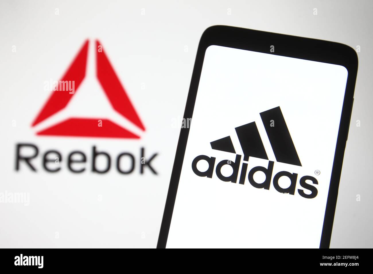 En esta ilustración de la foto el logo Adidas visto en un smartphone con un  logo Reebok en el fondo. (Foto de Pavlo Gonchar / SOPA Images/Sipa USA  Fotografía de stock -