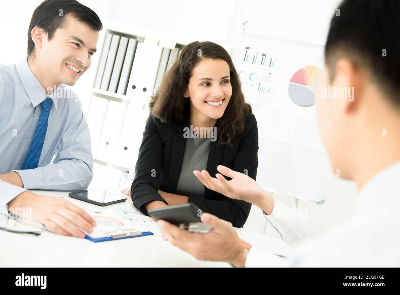 Hombre de negocios y mujer de negocios escuchando a su colega en la reunión Foto de stock