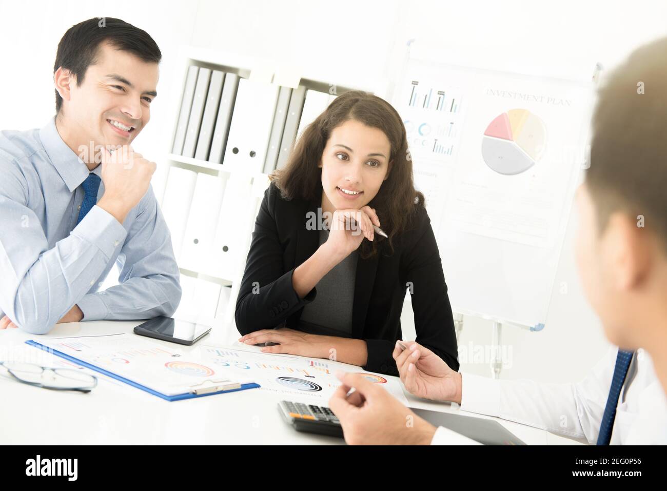 Hombre de negocios y mujer de negocios escuchando a su colega en la reunión Foto de stock