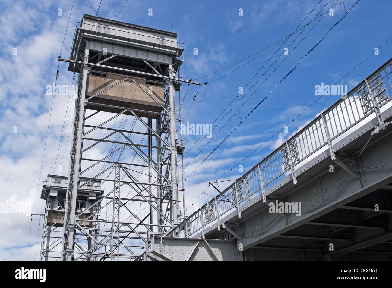 Construcción de metal blanco gris dos niveles de puente sobre el río, vista inferior de la segunda planta con vías de ferrocarril y dos pilares en forma de t Foto de stock
