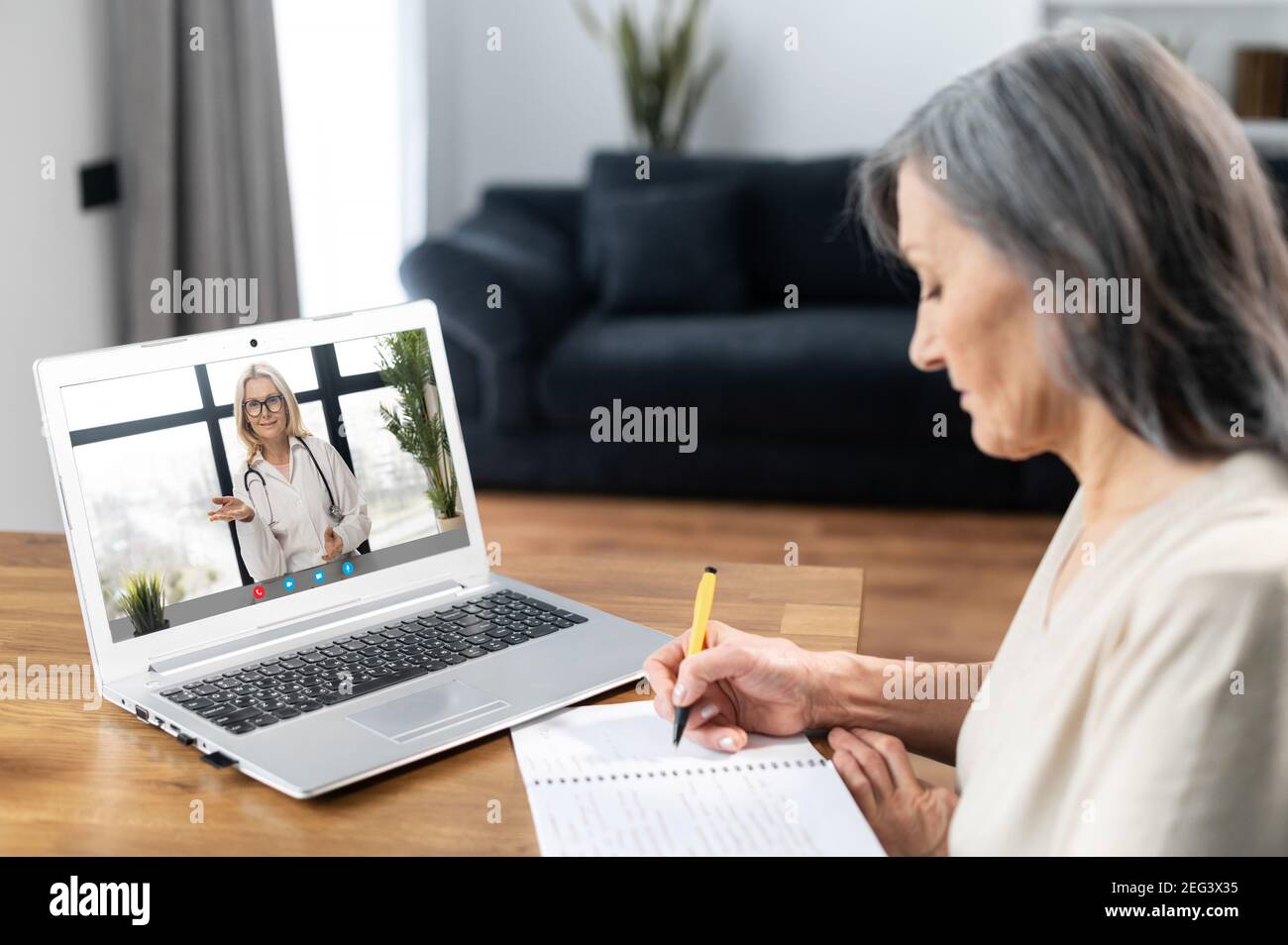 Mujer madura se sienta en la mesa en casa tienen videollamada con el  médico, utilizando conexión virtual en el portátil, mujeres paciente habla  con webcam Fotografía de stock - Alamy