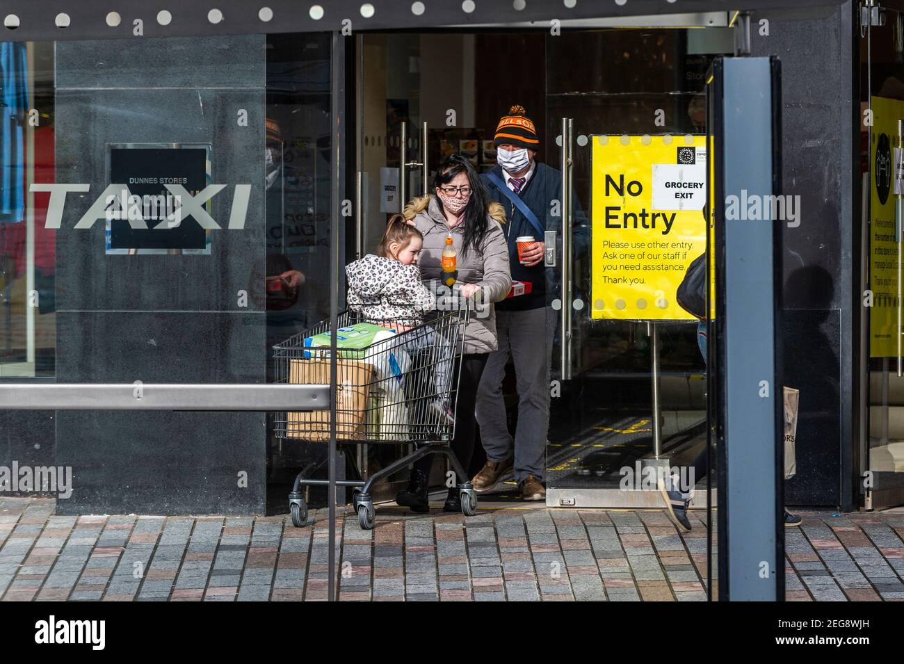 Cork, Irlanda. 18 de febrero de 2021. La gente en el centro de la ciudad de Cork hace sus negocios durante el cierre de nivel 5 del gobierno. Crédito: AG News/Alamy Live News Foto de stock