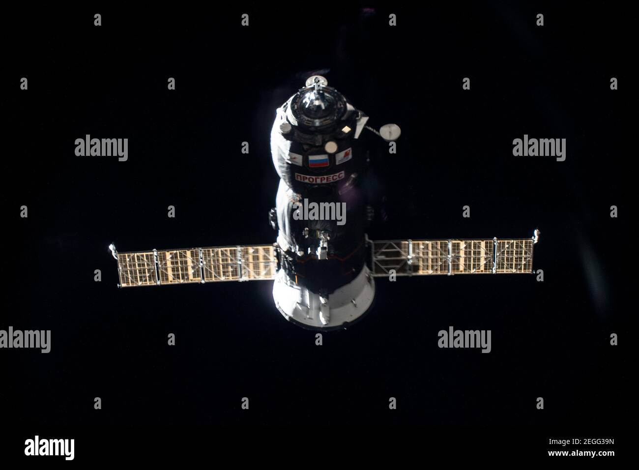 Estación Espacial Internacional, órbita terrestre. 17 de febrero de 2021. La nave espacial rusa no tripulada Progress 77 se aproxima al puerto de atraque de los Pirs en la Estación Espacial Internacional el 17 de febrero de 2021 en órbita terrestre. Un thruster se ve disparando durante una quemadura para afinar el camino hacia su puerto de acoplamiento. Crédito: Planetpix/Alamy Live News Foto de stock