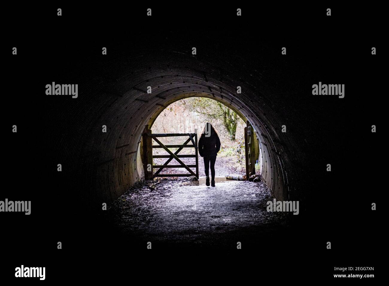 Una mujer solitaria caminando en un túnel bajo la autopista M62 en el embalse de Scammonden, Yorkshire, Reino Unido Foto de stock