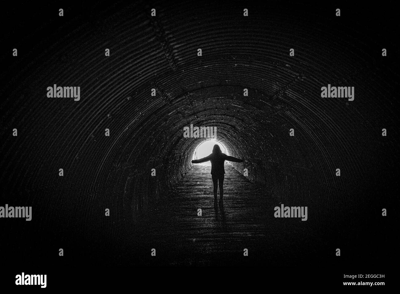 Una mujer solitaria caminando en un túnel bajo la autopista M62 en el embalse de Scammonden, Yorkshire, Reino Unido Foto de stock