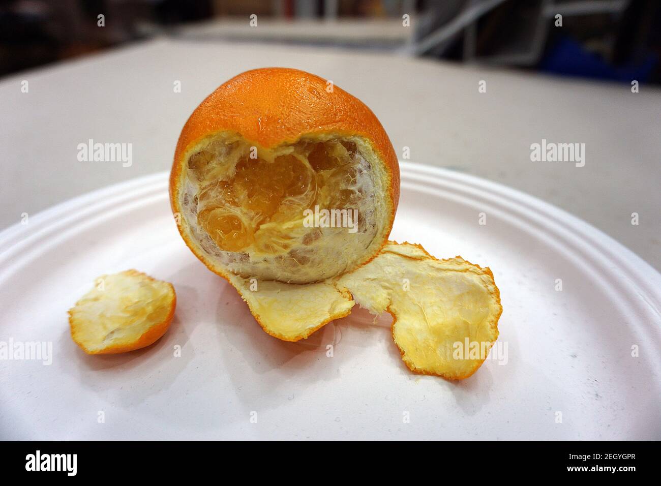 Pelado, naranja, puesto en una mesa blanca Foto de stock