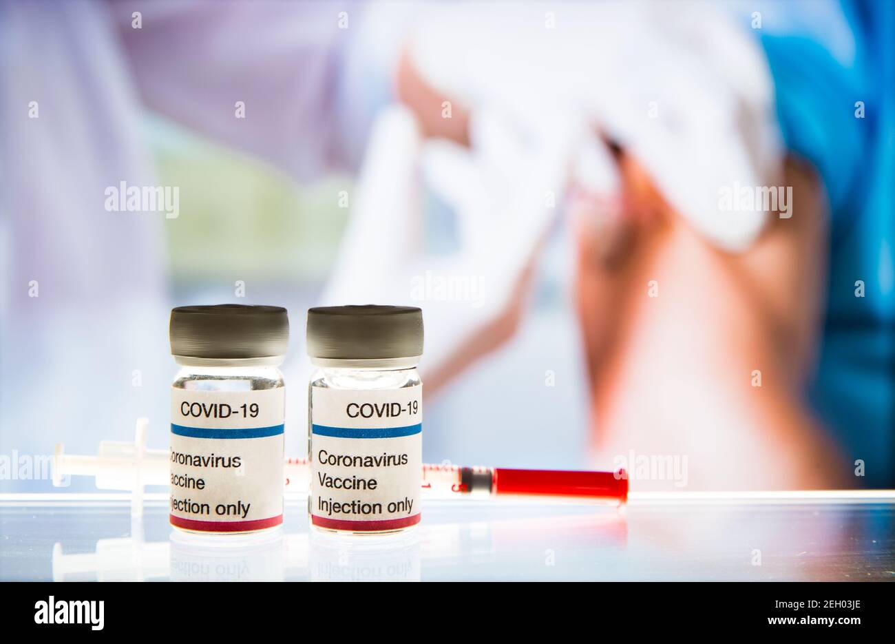 Primer plano de la vacuna COVID-19. Médico femenino con máscara quirúrgica y en guantes que dan la inyección de la vacuna al hombre en el hospital. Vacunación durante el coronavirus Foto de stock