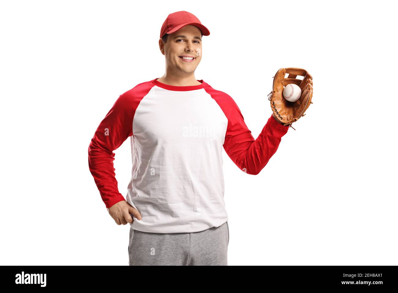 Hombre sonriente que captura una pelota de béisbol con un guante aislado sobre fondo blanco Foto de stock