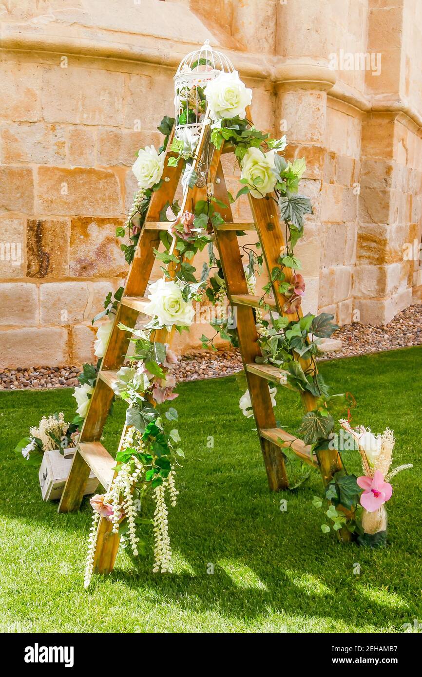 Decoración floral para celebrar una fiesta al aire libre con una escalera  de madera y flores en el jardín Fotografía de stock - Alamy