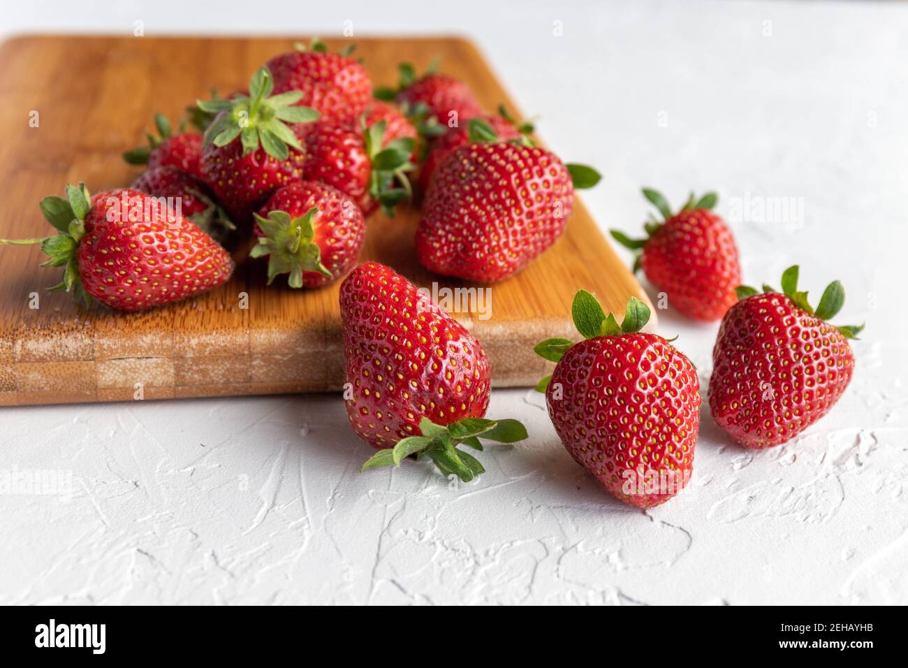 Fresas rojas y maduras frescas del Jardín en el tablero de madera Foto de stock