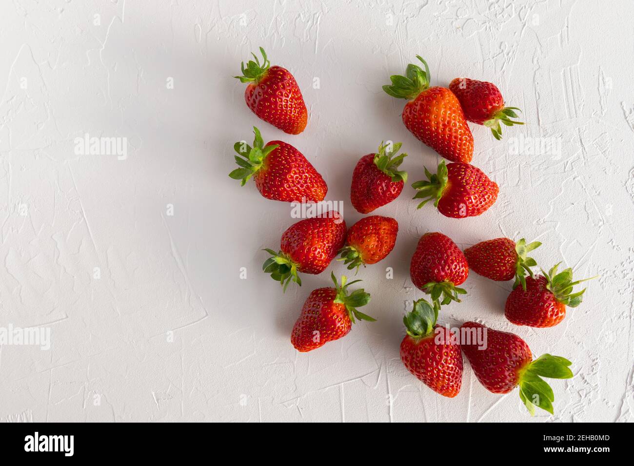 Fresas rojas y maduras frescas del Jardín sobre fondo blanco texturizado Foto de stock