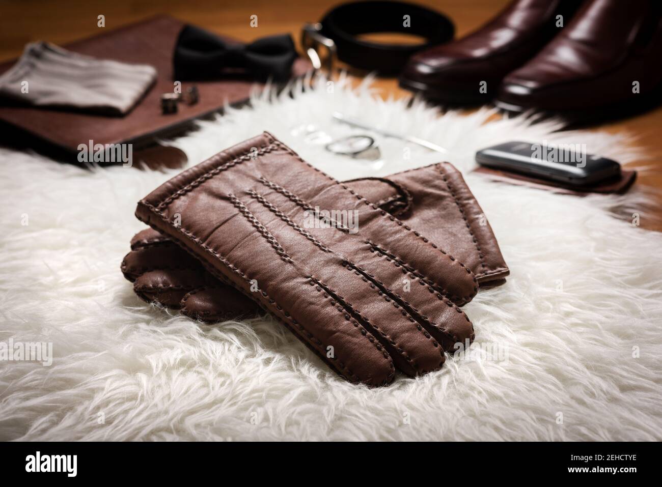 Par de guantes de cuero marrón para hombre y otros accesorios para hombre  sobre piel blanca Fotografía de stock - Alamy