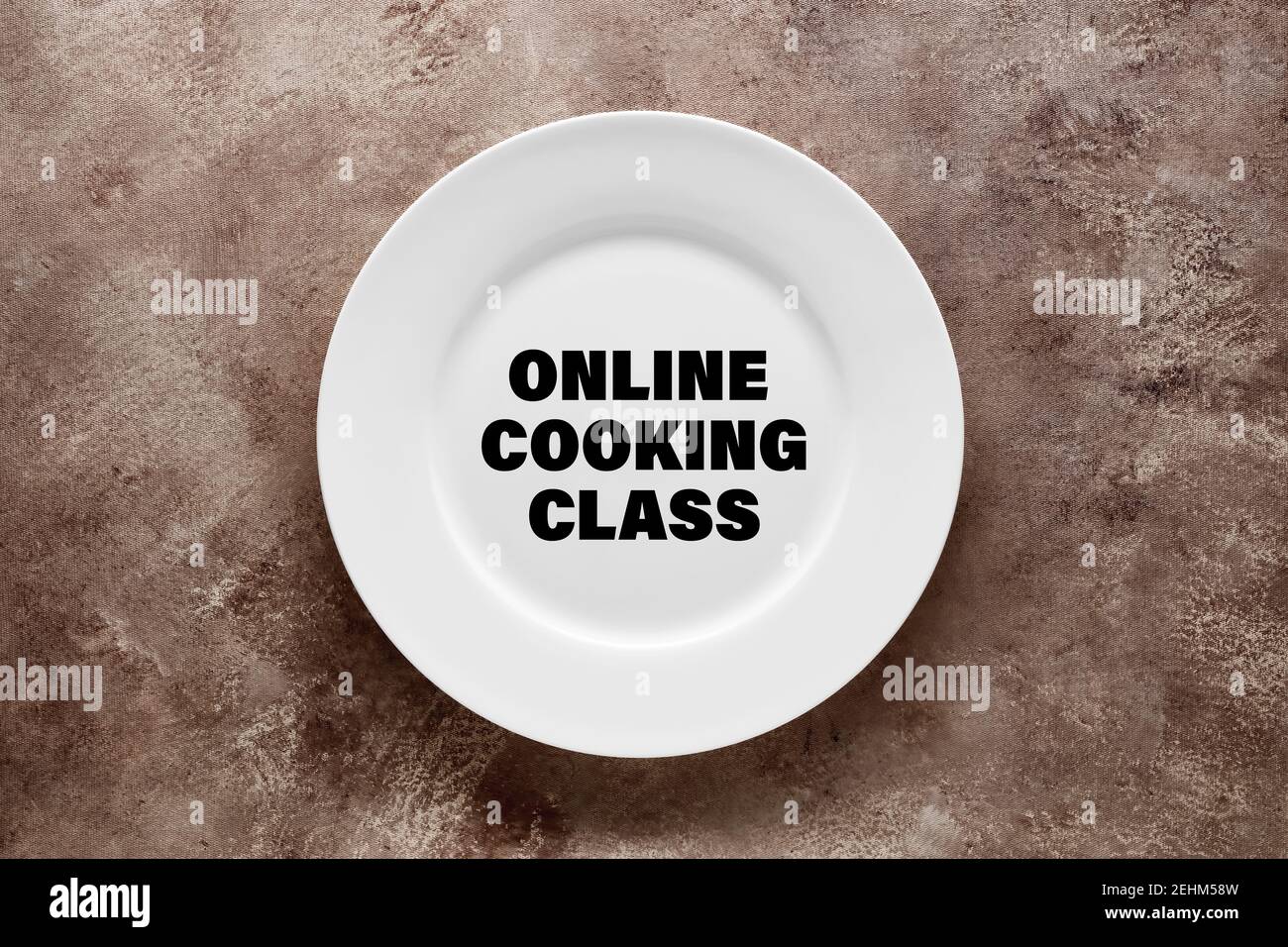 La palabra clase de cocina en línea escrita en un plato blanco. Concepto de formación o formación en línea. Foto de stock