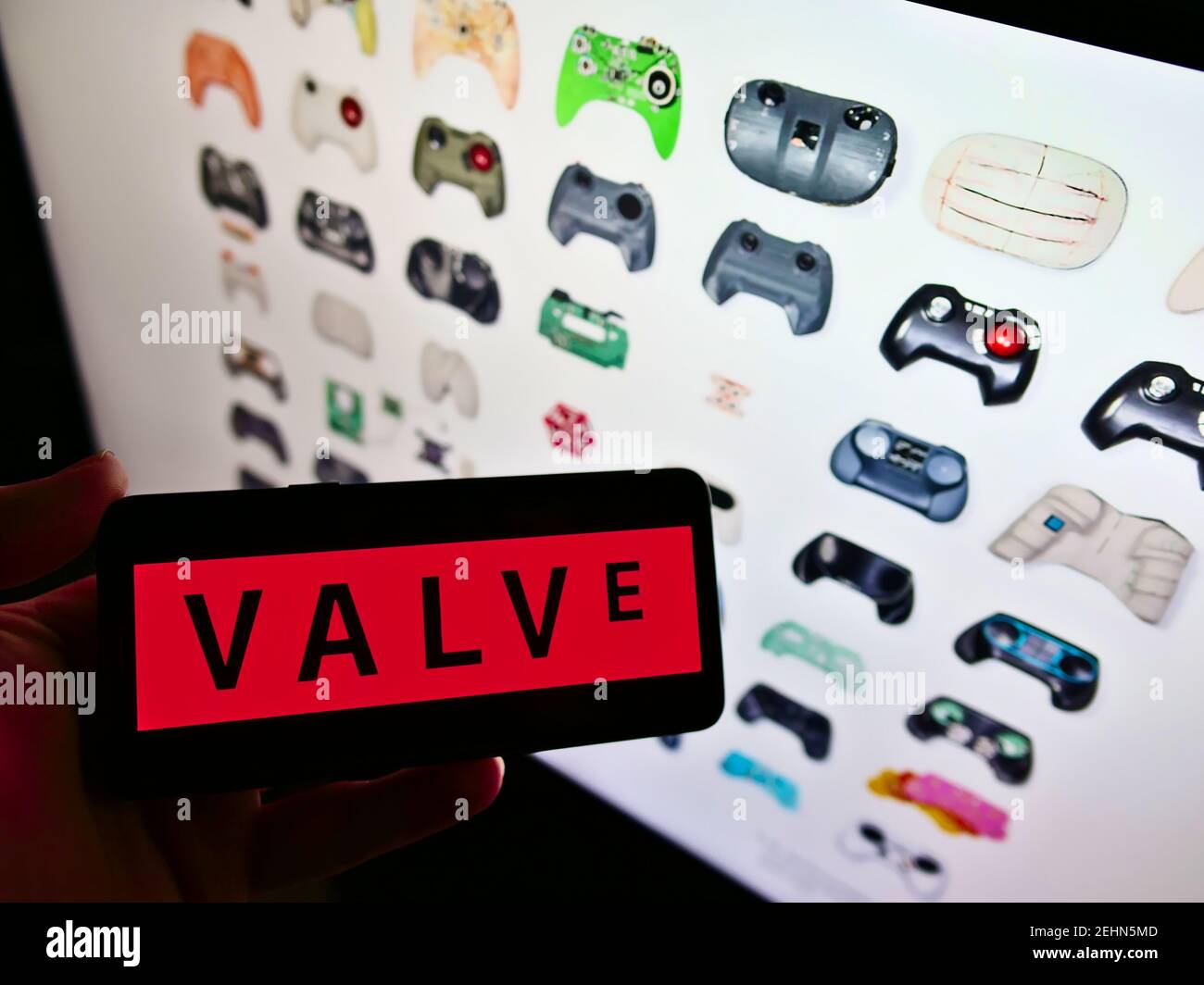 Vista De Gran Angulo De La Persona Que Sostiene El Telefono Movil Con El Logotipo De La Empresa De Videojuegos De Ee Uu Valve Corporation En La Pantalla Con El Sitio Web Enfoque