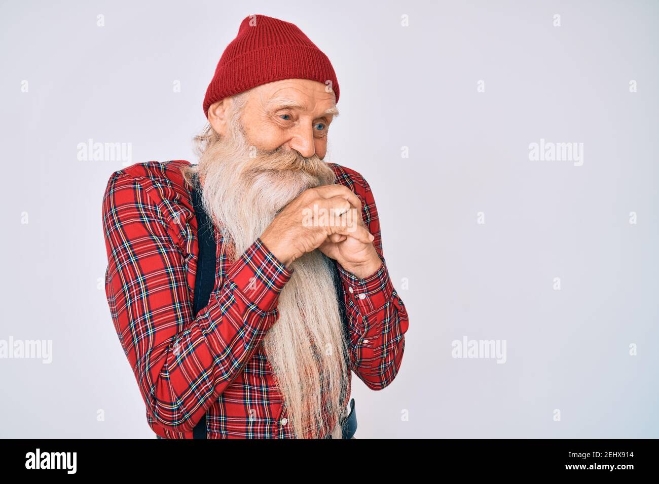 Viejo anciano con pelo gris y barba larga hipster look con gorro de lana  riendo nervioso y emocionado con manos en la barbilla mirando hacia un lado  Fotografía de stock - Alamy