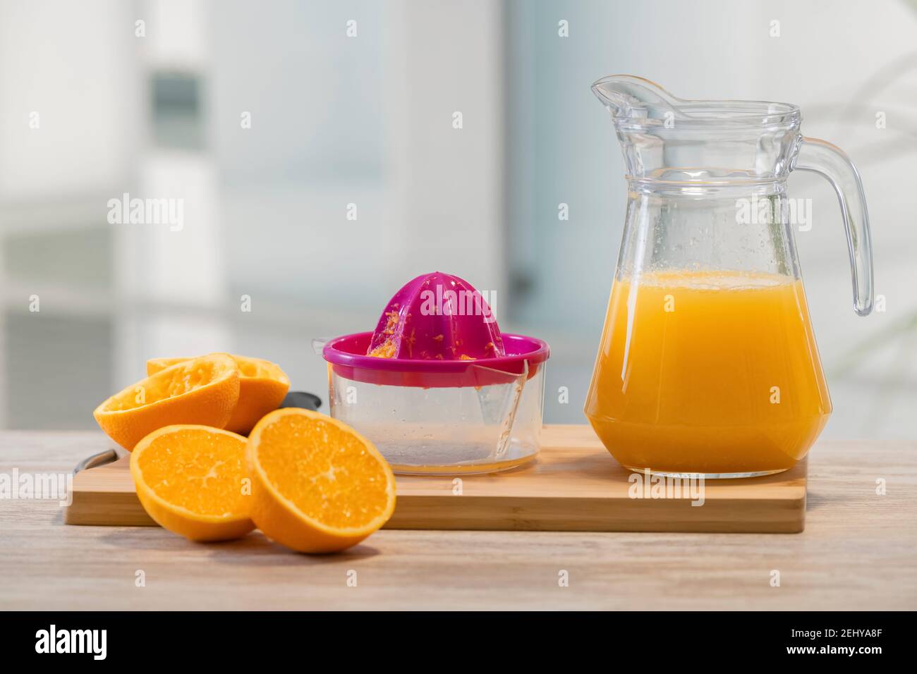 vista de un exprimidor manual en tabla de madera y a las naranjas  siguientes y un lanzador de vidrio con jugo de naranja. enfoque selectivo.  vitamina y foo saludable Fotografía de stock -