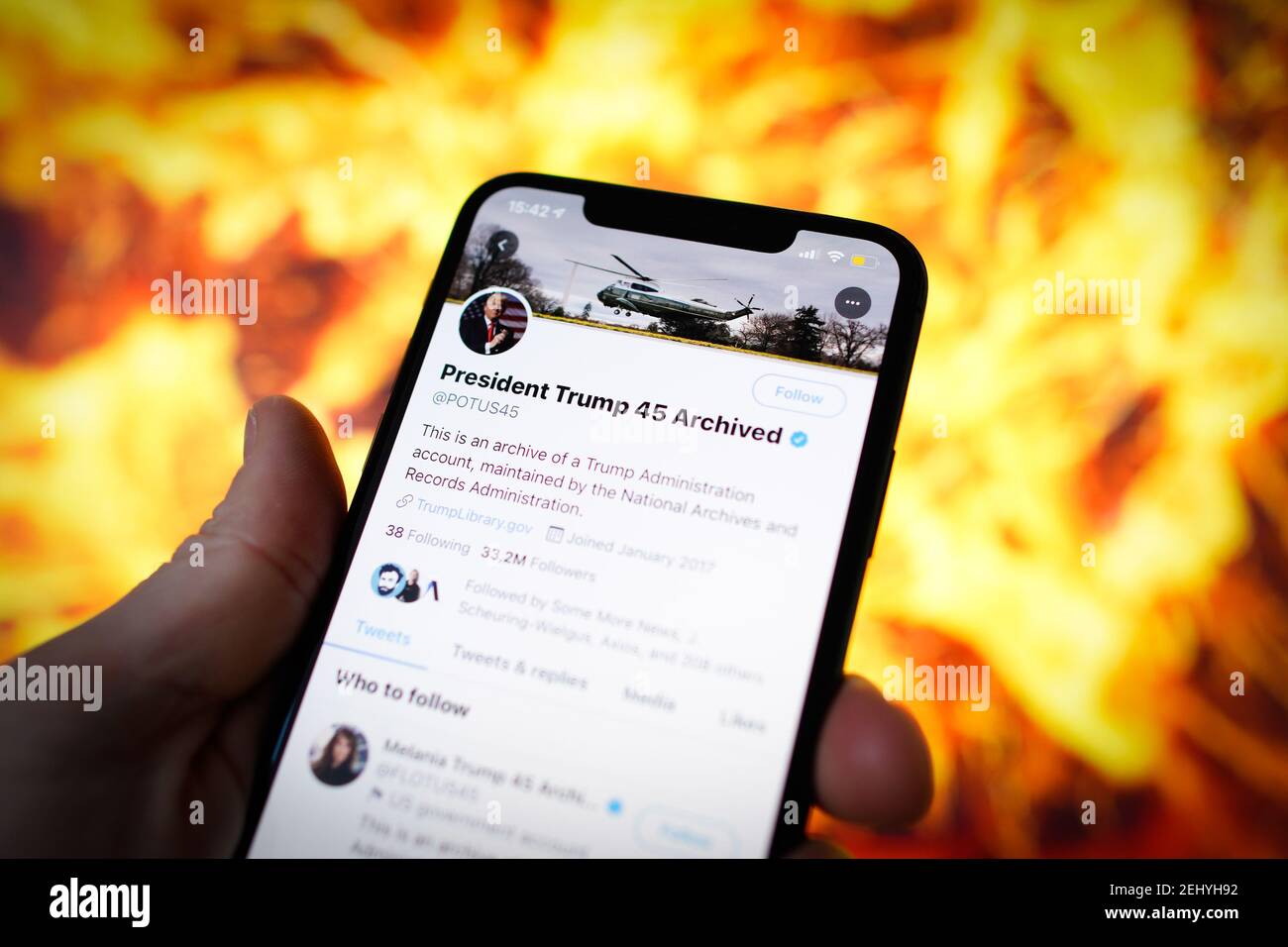 Los tweets archivados del 45º presidente de Estados Unidos, Donald Trump, se ven en un dispositivo móvil con una ilustración de una explosión en la ba Foto de stock