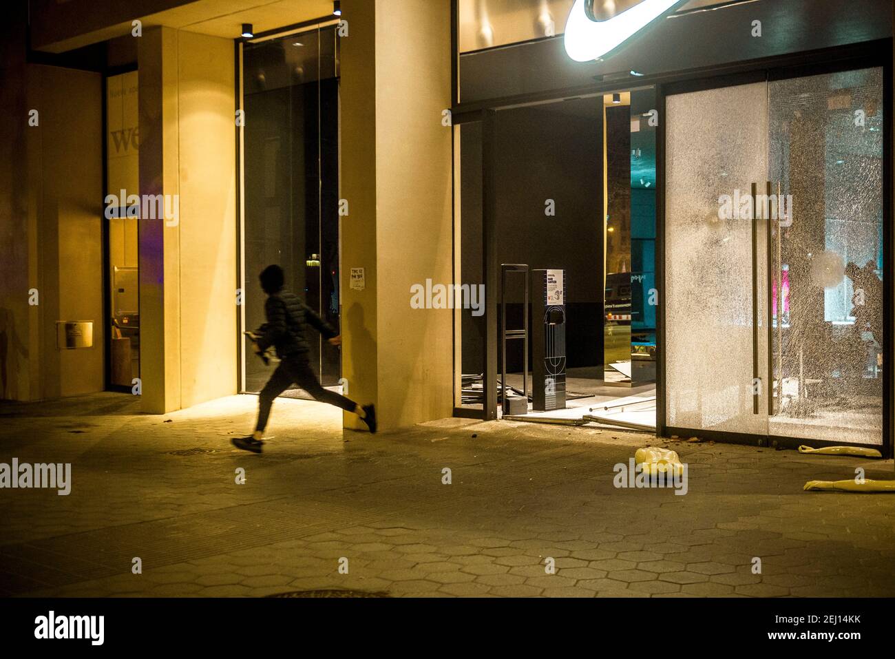 Barcelona, España. 20 de febrero de 2021. Los saqueadores salen de una tienda  Nike en el centro de Barcelona como una protesta tras el encarcelamiento  del rapero 'Pablo Hasel', condenado a la